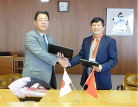 JFE Steel Senior Vice President Shichinobu Nasu (left) and AGRIMECO President and CEO Le Van An
shake hands after signing the joint venture agreement on December 2, 2016
